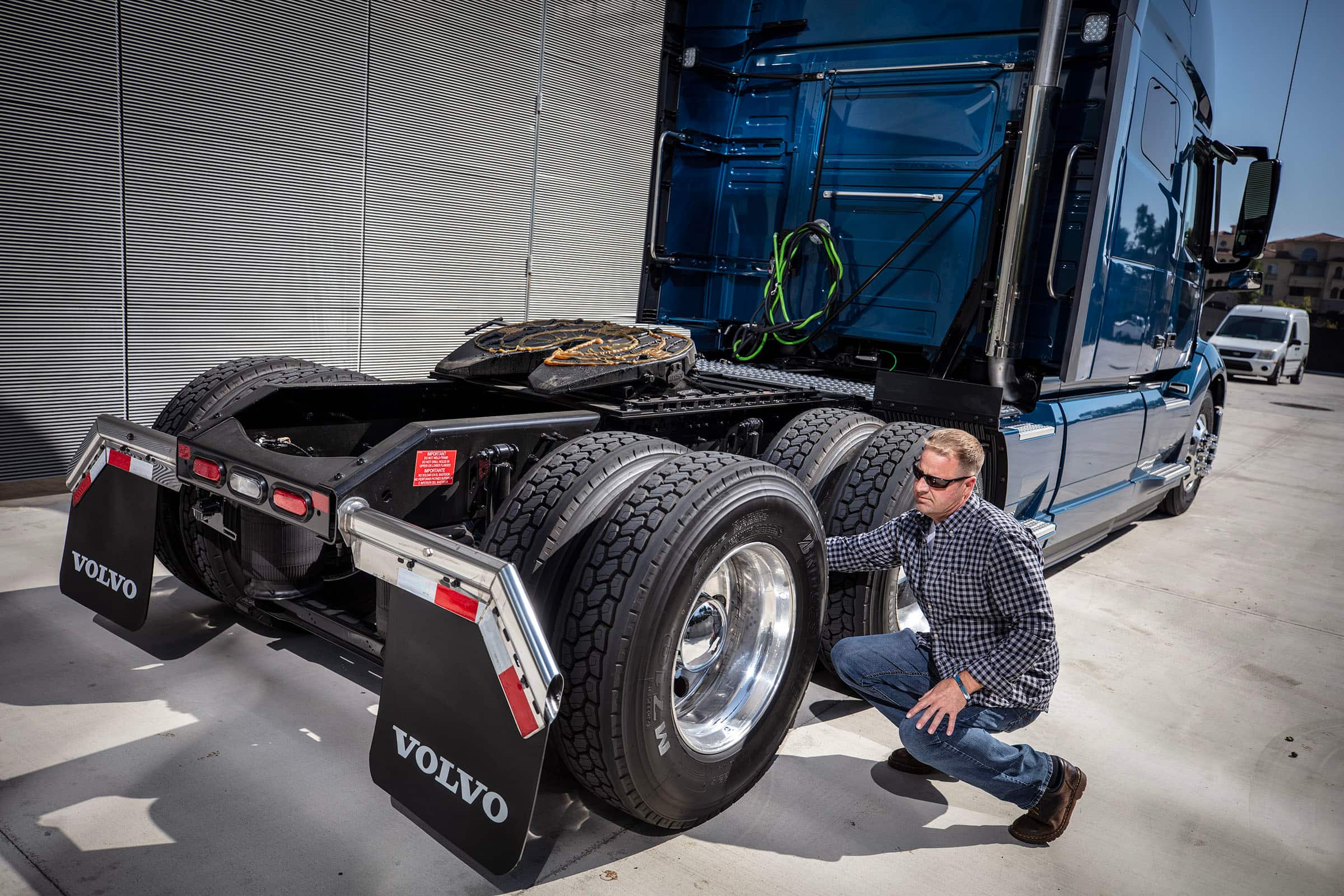driver inspecting a semi truck's tires